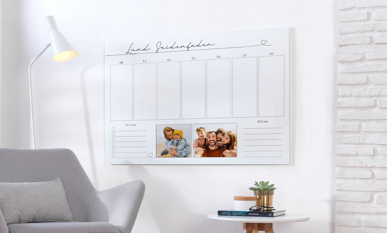 En vacker väggkalender med fotoplats för personliga minnen, på en hylla över en mysig fåtölj.
