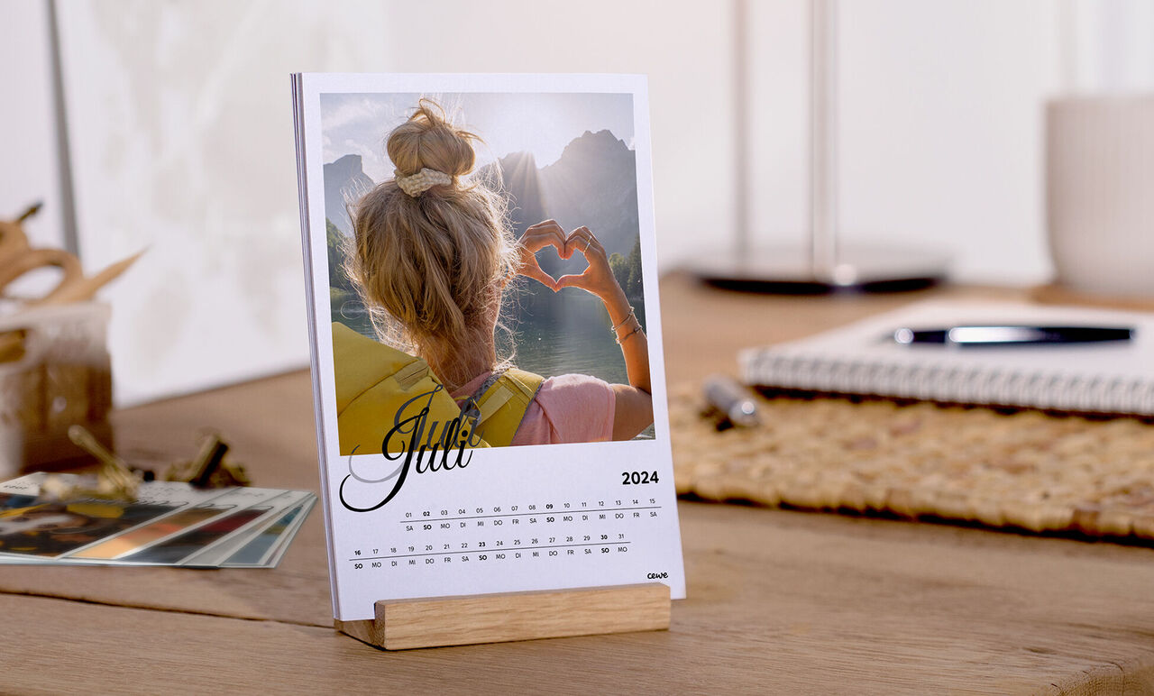 Gratis bordskalender för juni 2025, med ett kärleksfullt foto av en person som formar ett hjärta med händerna.