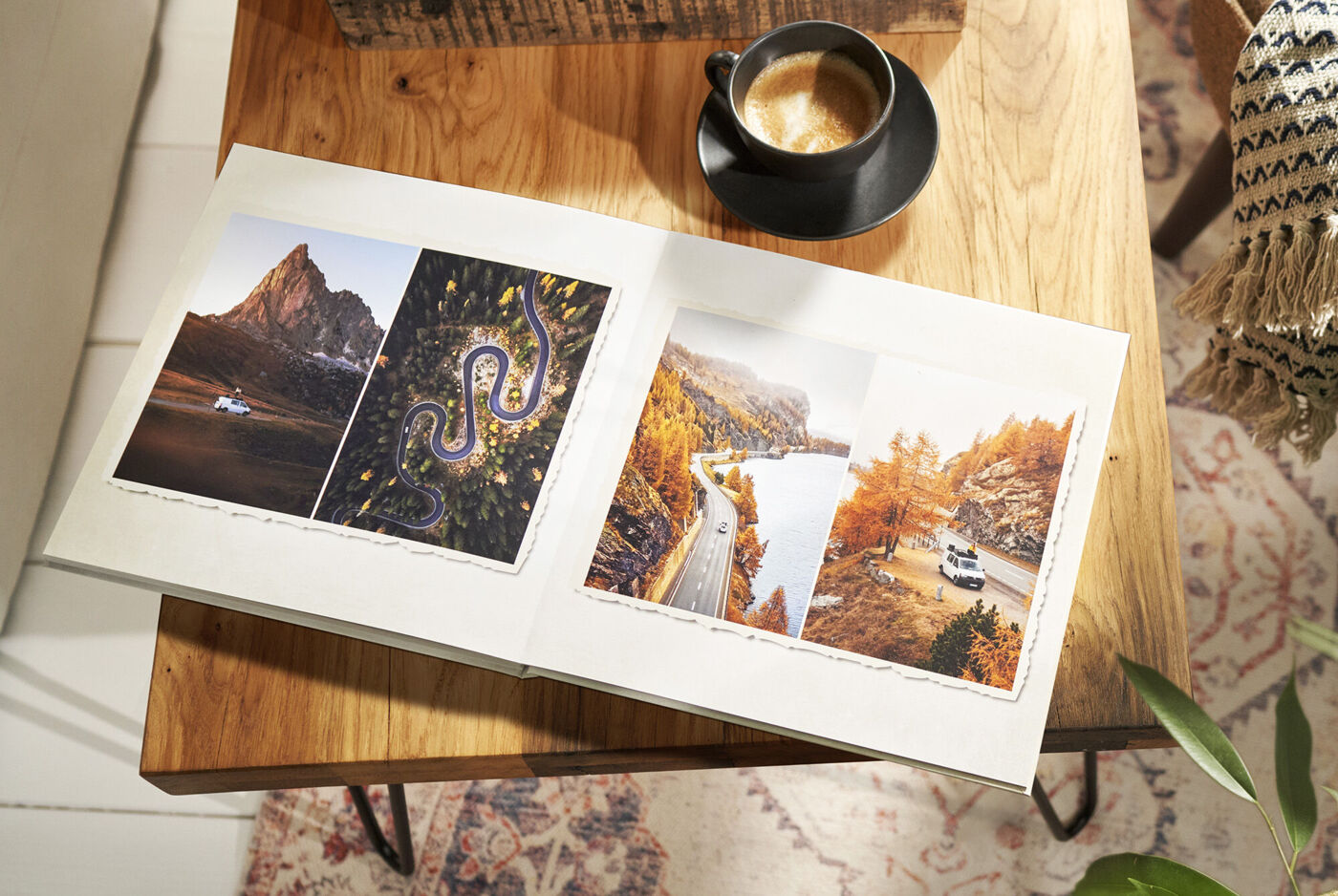 Öppen CEWE-fotobok med reseminnen på ett trädgårdsbord, bredvid en kopp kaffe.