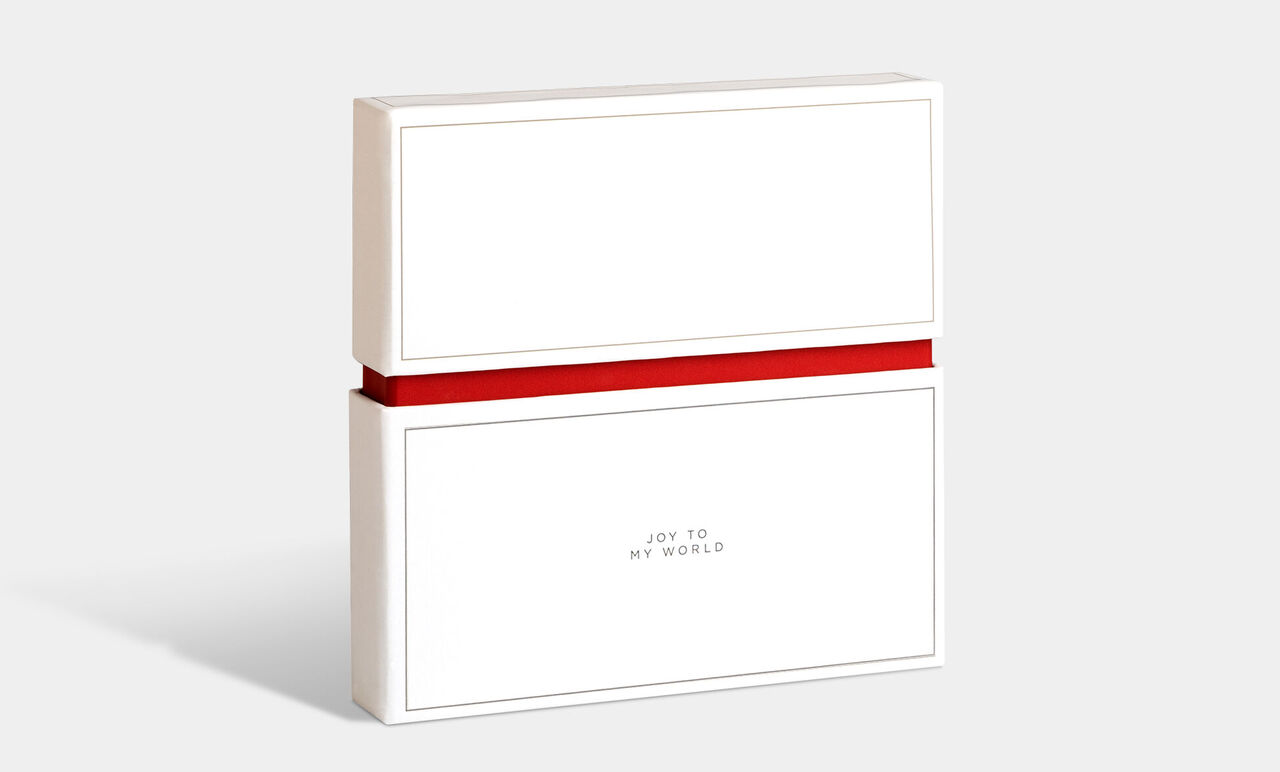 Presentförpackning i vitt med röd band, märkt med 'Joy to my world'.