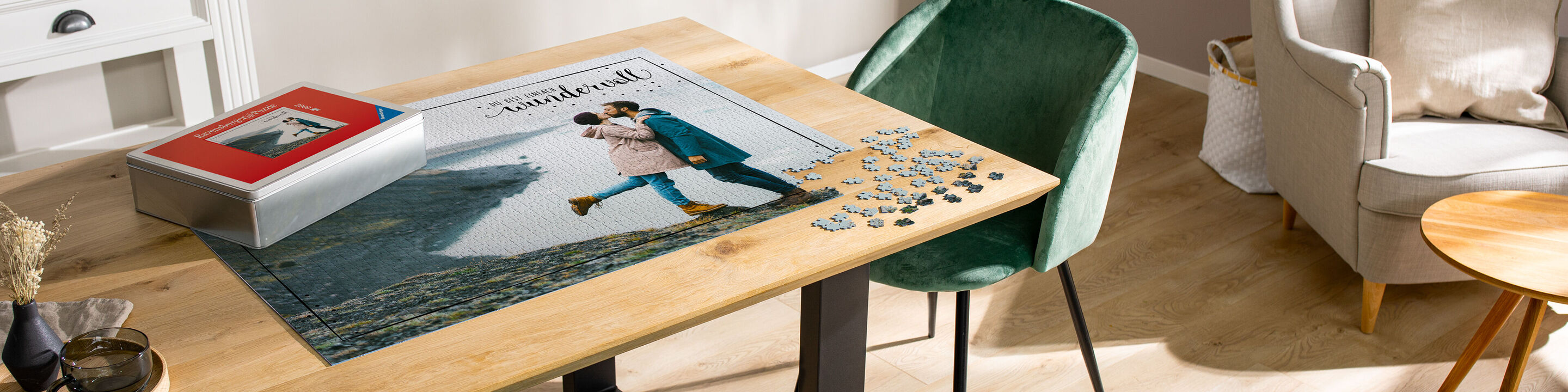 En CEWE fotobok ligger på ett träskrivbord. Bordet är modernt och vackert inrett. Pusselbitar är spridda på bordet.