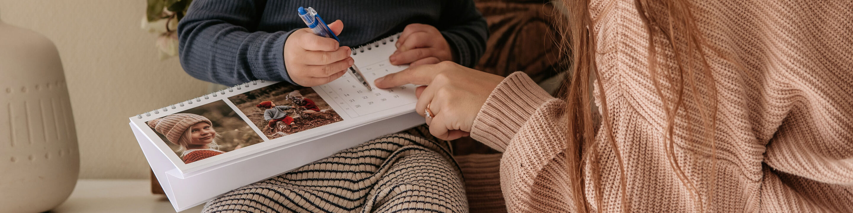 En mamma visar sitt barn en kalender med vackra bilder