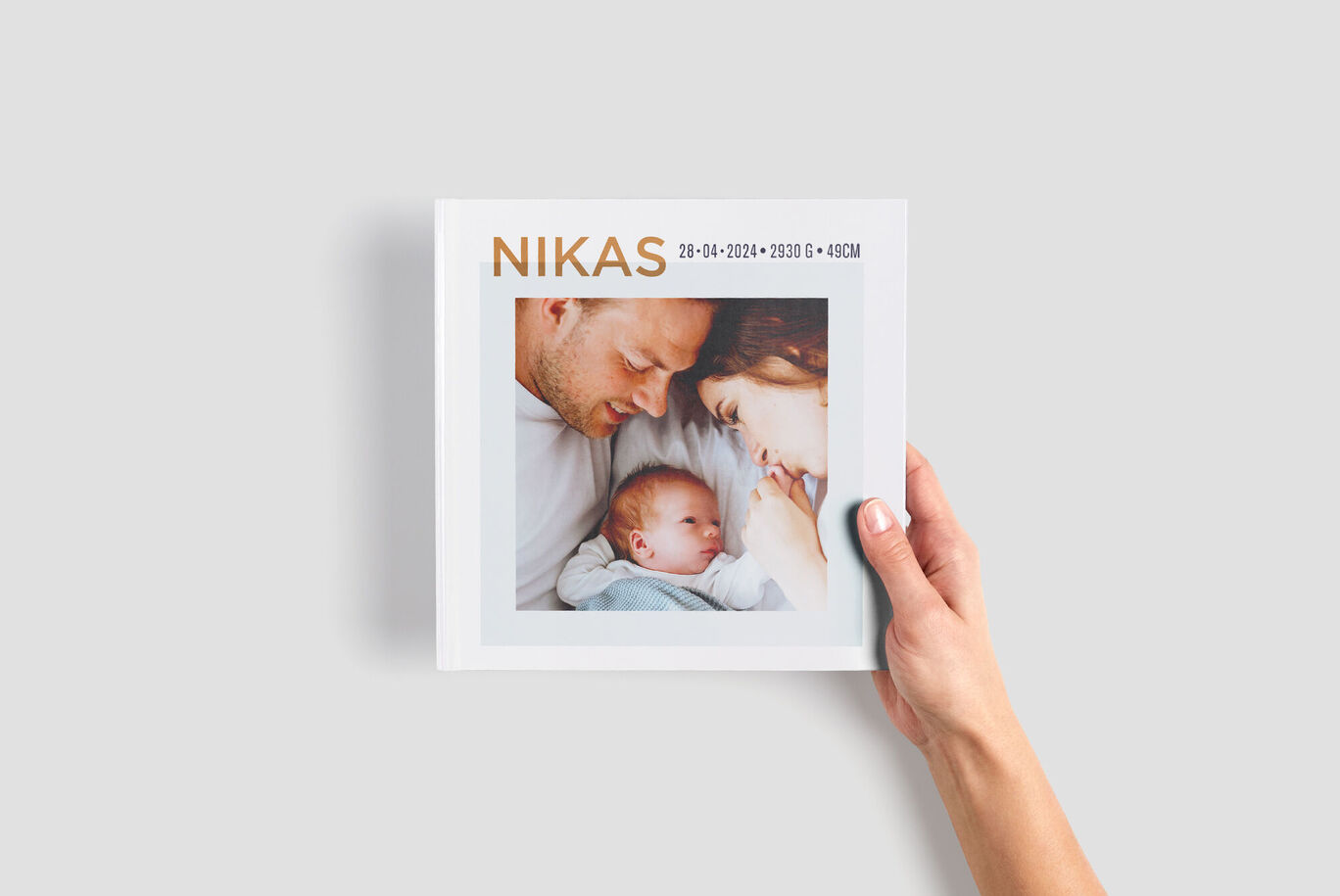 En kärleksfull designad fotobok med namnet "NIKAS" och två bilder på framsidan. Den visar glädjen över den nya livsfasen.