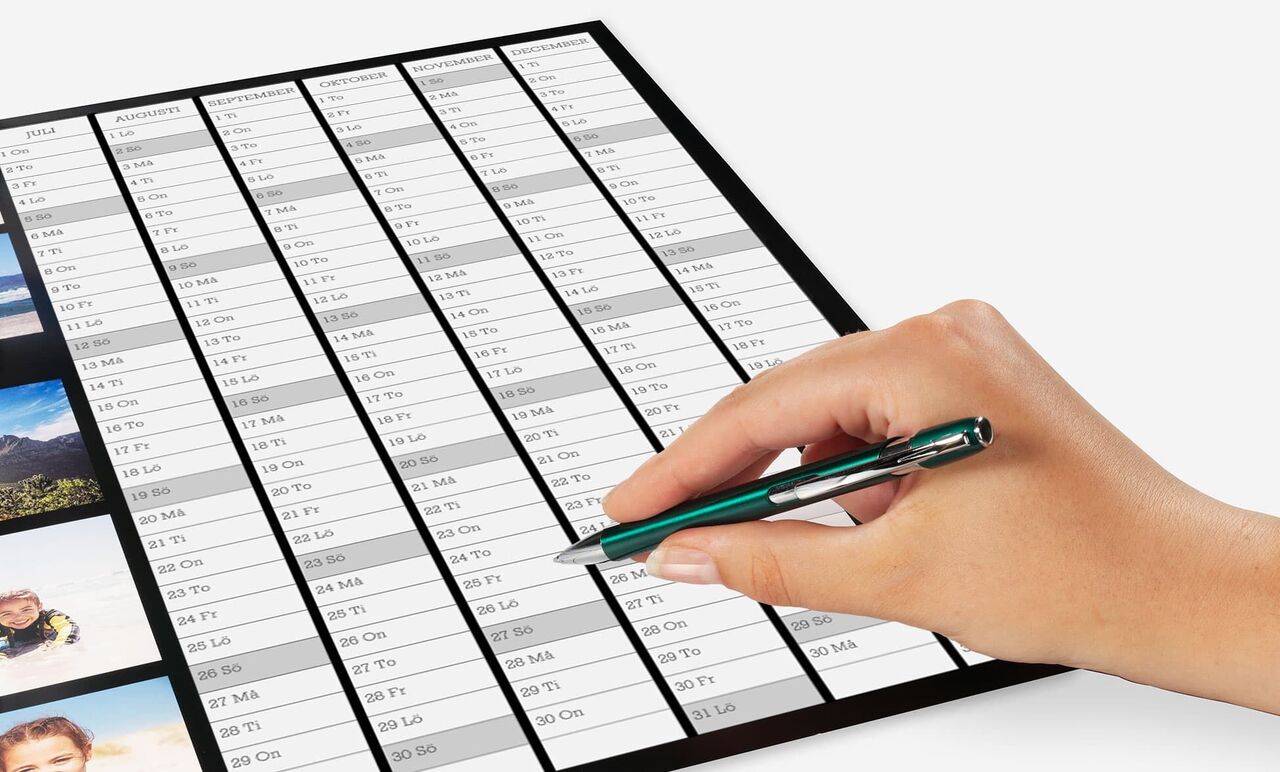 En hand med en penna som fyller i en planering eller lista.