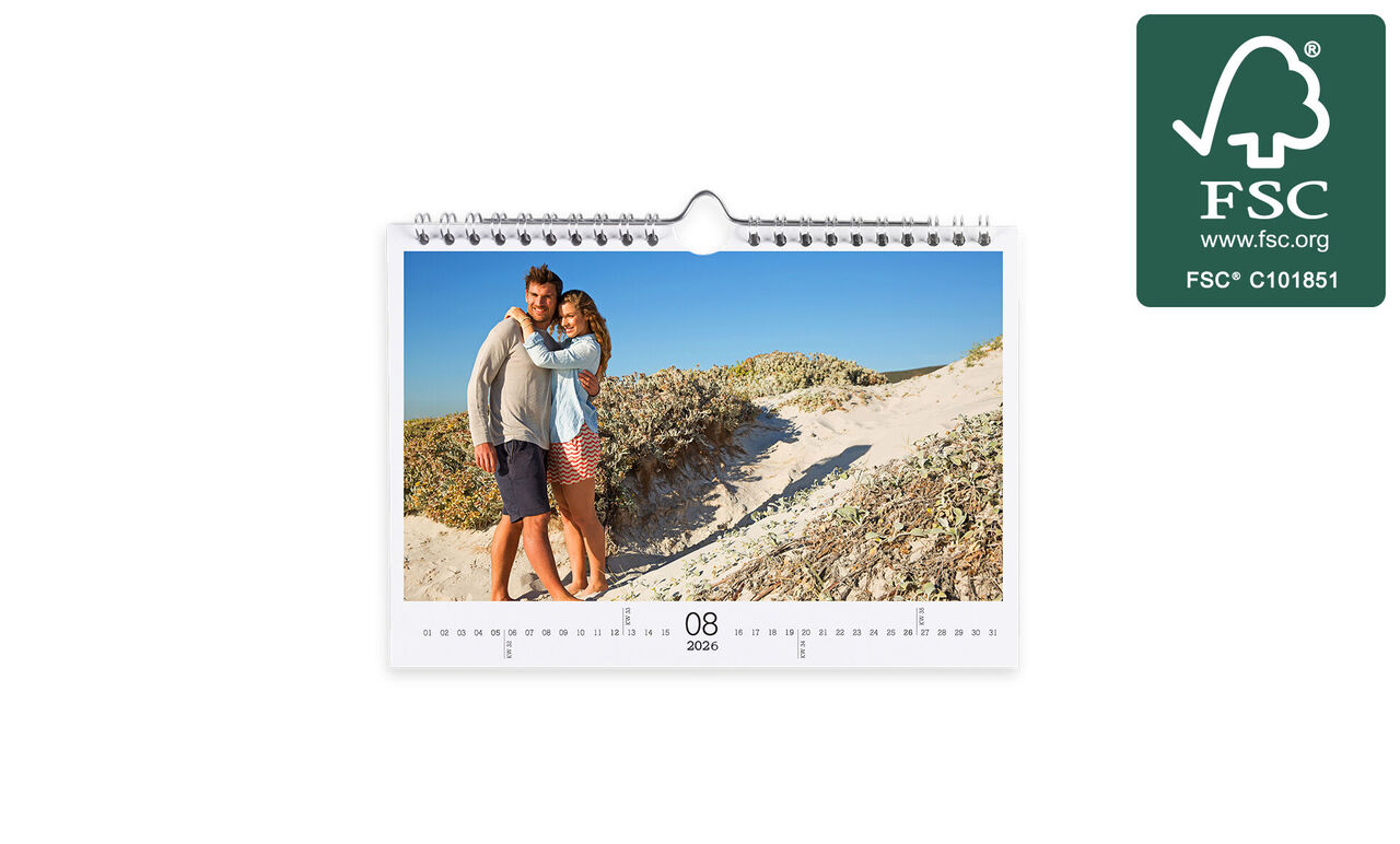 Kärleksfullt par poserar på stranden i en fotokalender.