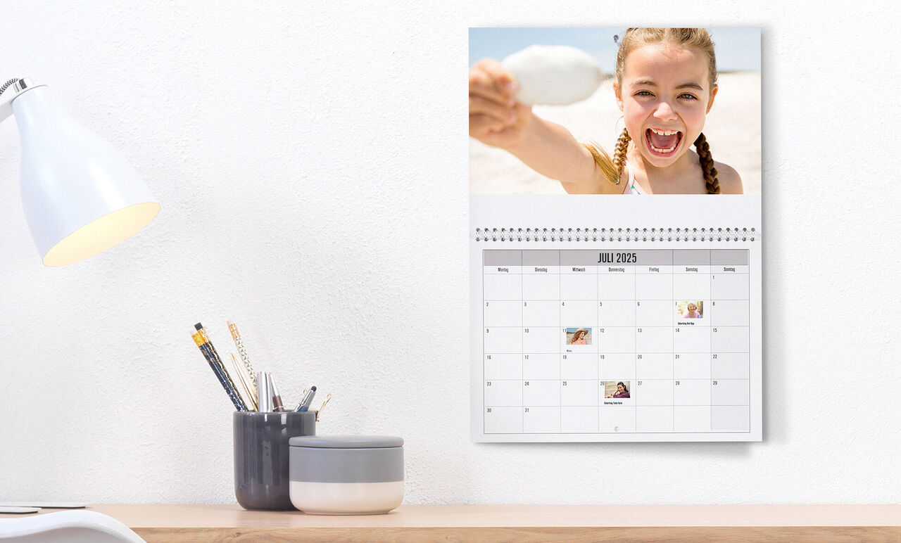En personlig väggkalender med foton och anteckningar för juli 2023.