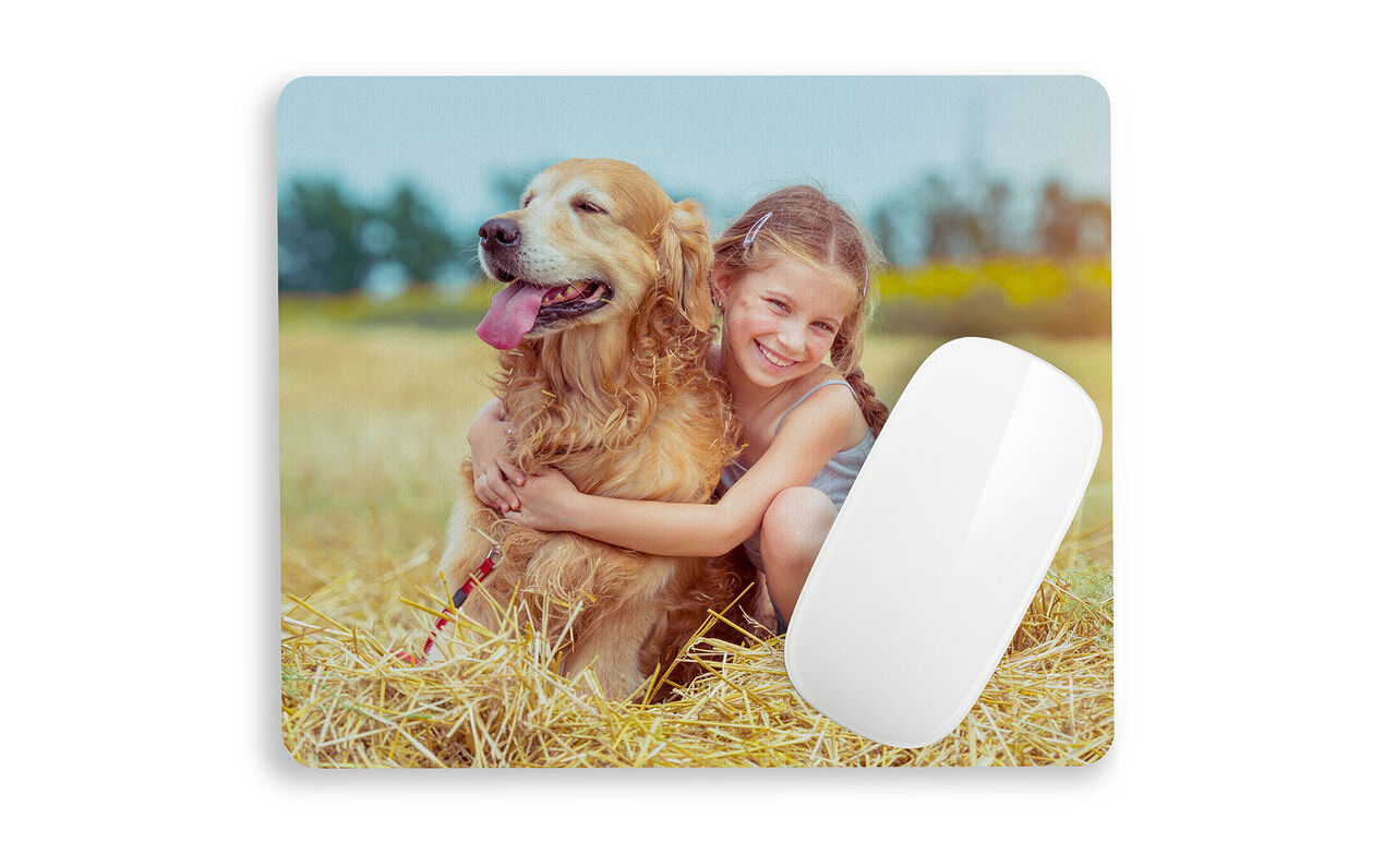 Ett flicka kramar en golden retriever på ett fält.