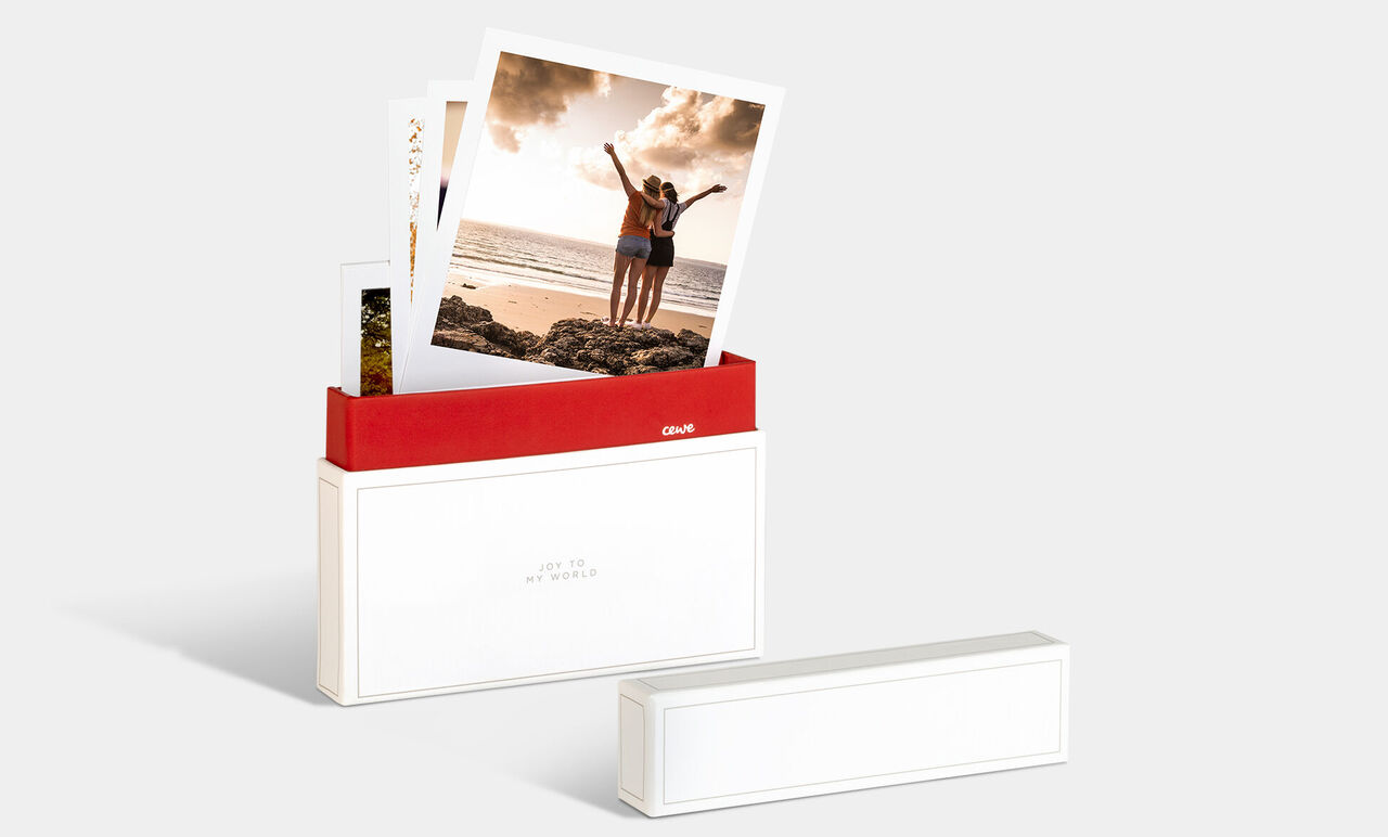 En CEWE fotobox med bilder av två glada personer på stranden.