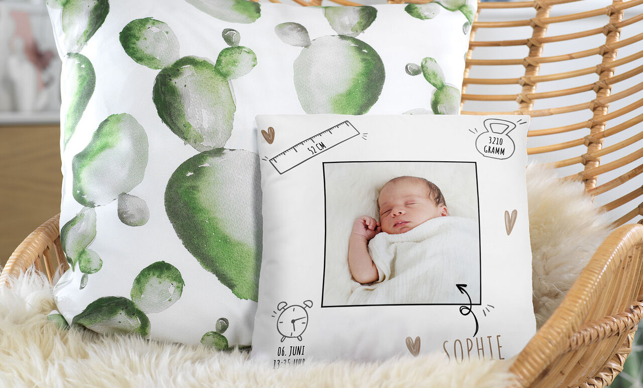Mysig hemmamiljö med kuddar och en personlig kudde med ett babymotiv.