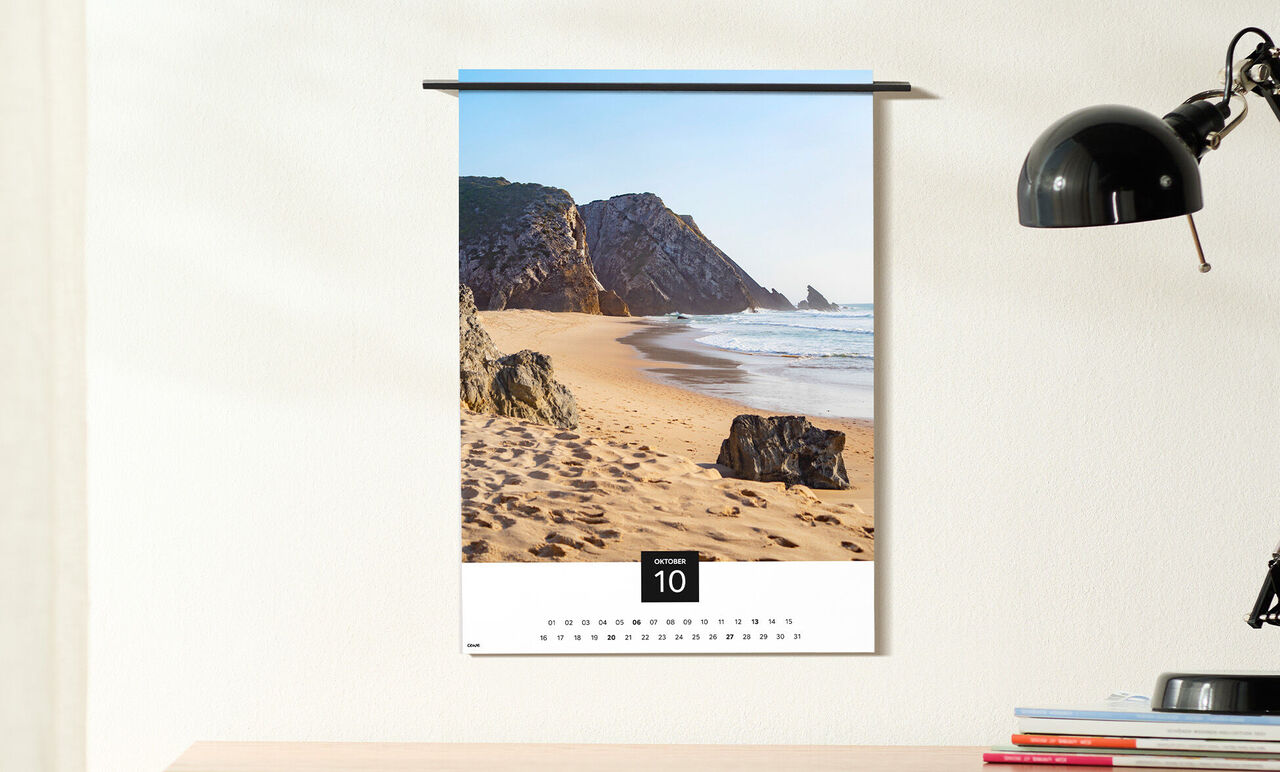 Kalender med ett vackert strandmotiv och klippor vid kusten.