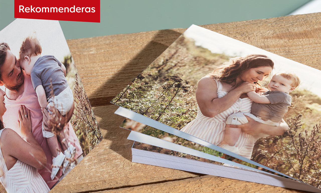 En glad mamma håller sitt barn utomhus. Vackra gröna färger i bakgrunden. CEWE FOTOBOK.