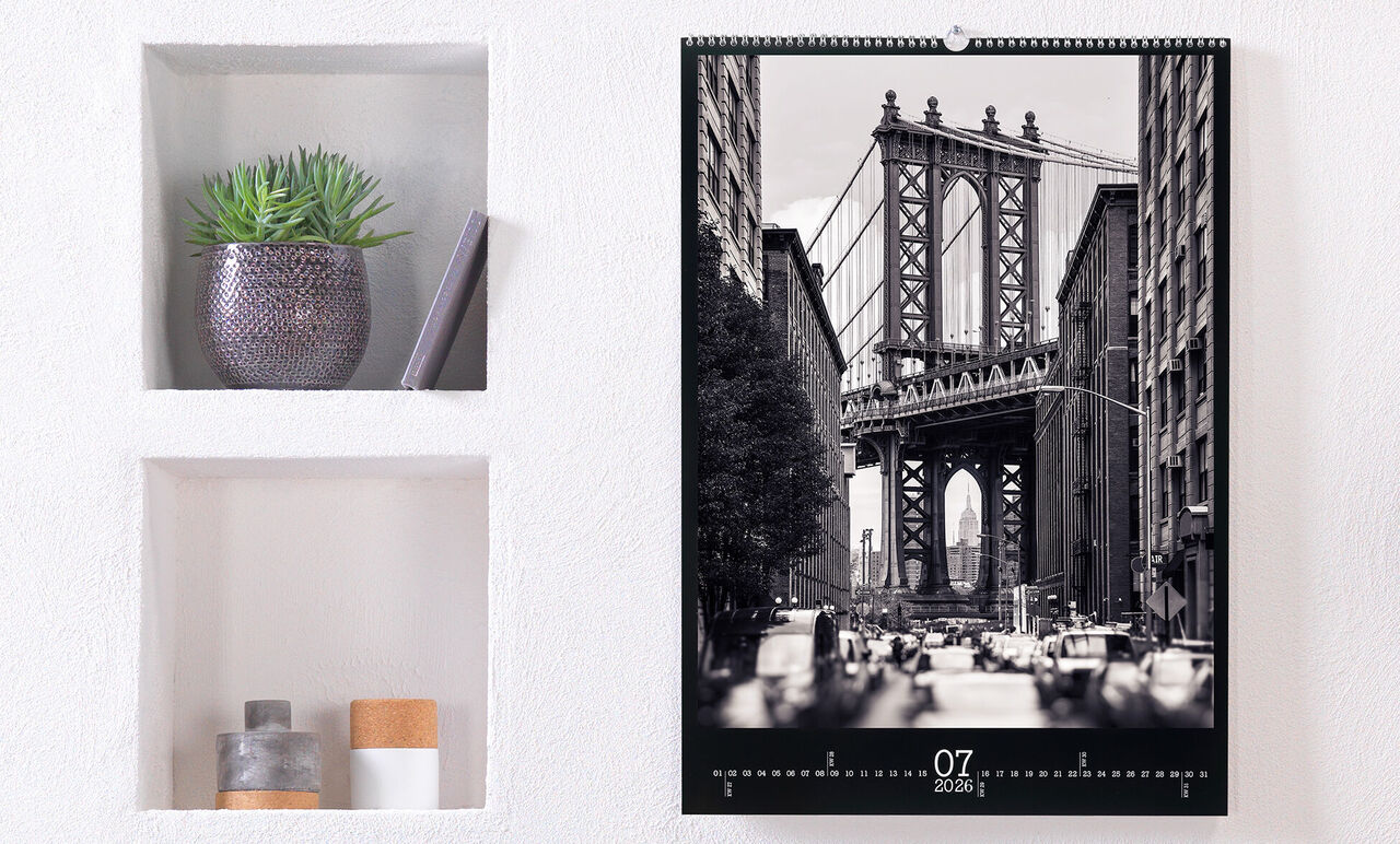 Kalender med svart-vit bild av Brooklyn Bridge, dekorerad med växter.