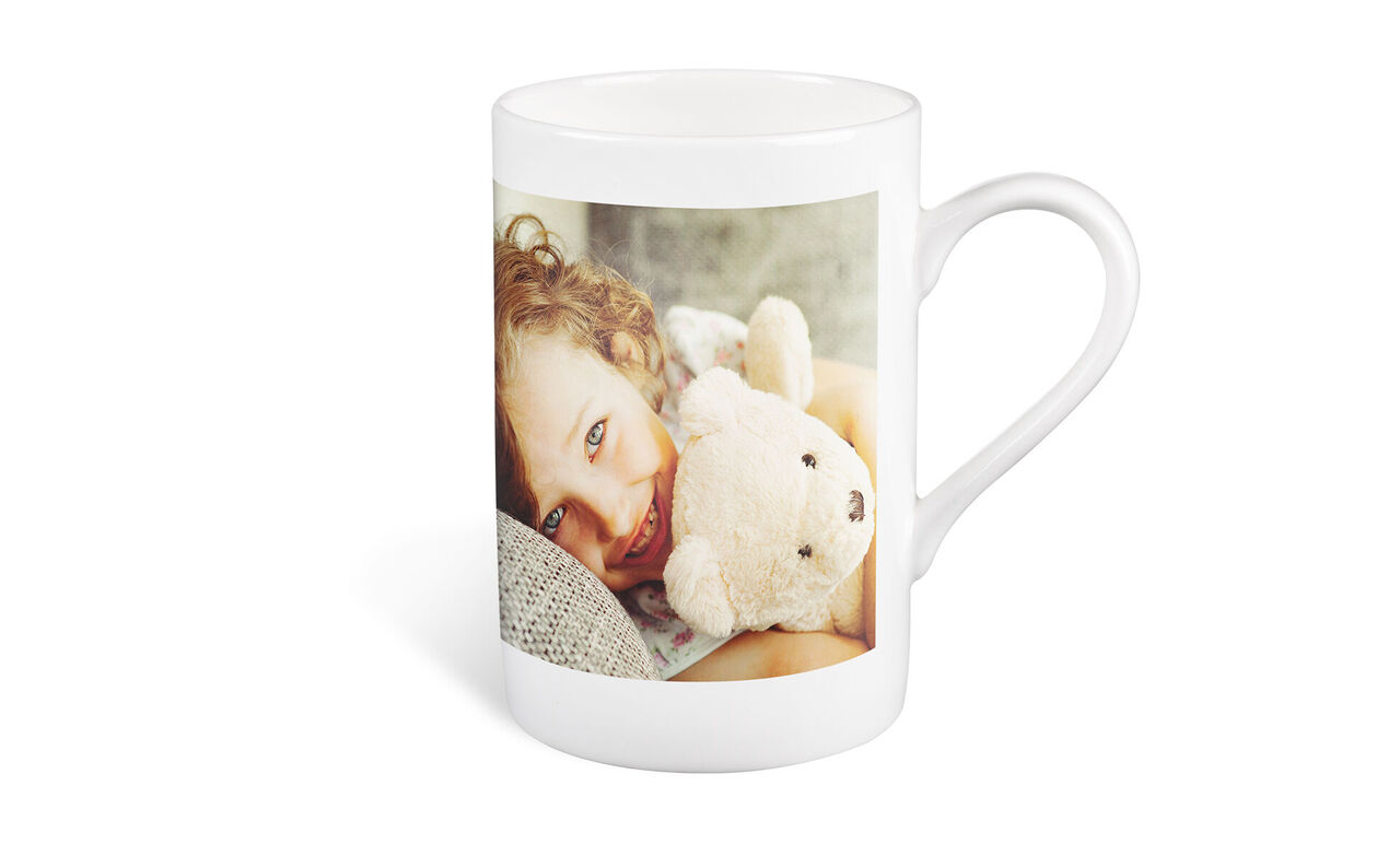 En mugg med foto och en mjuk nalledukke.