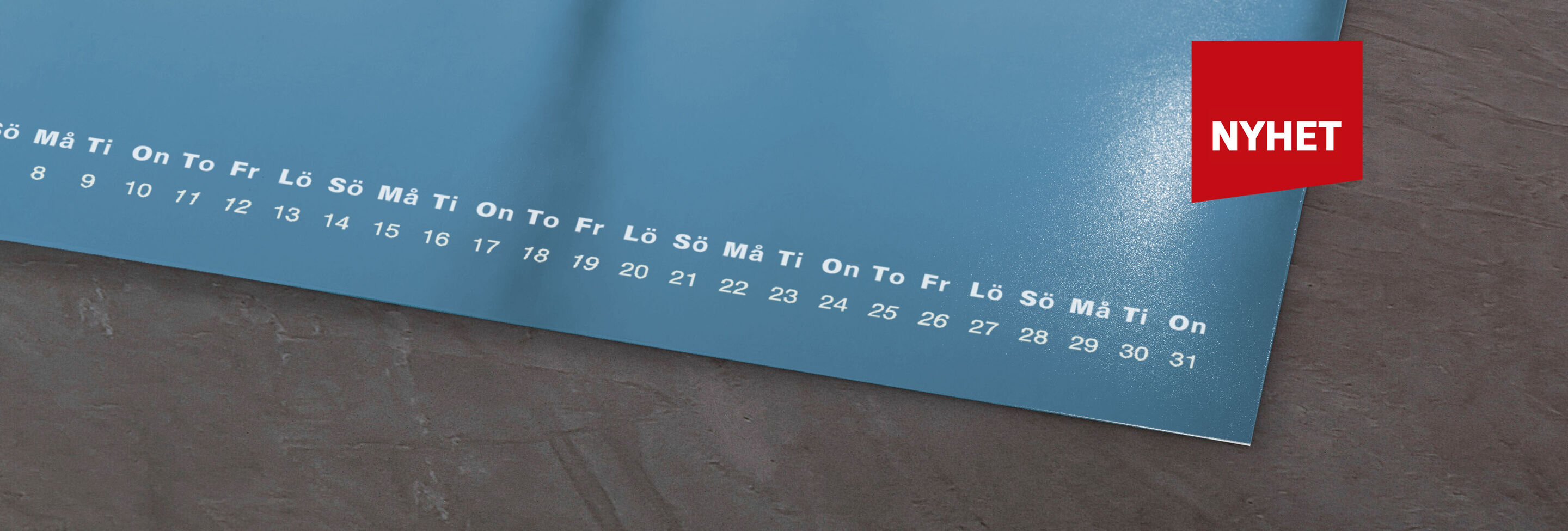 En kalender med blå yta och datum. En röd ruta ovanför med texten 'NYHET'.