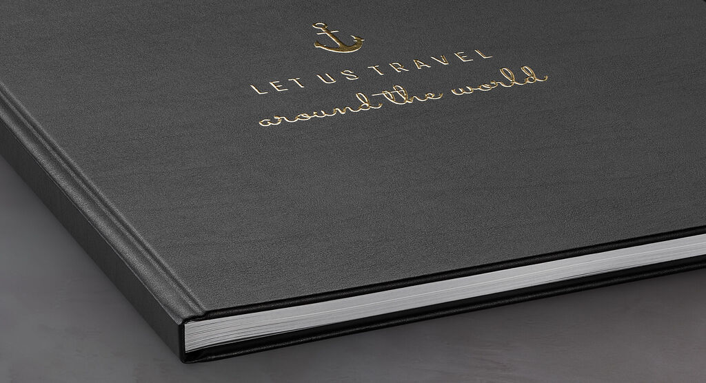 Svart fotobok med guldprägling "Låt oss resa världen runt"
