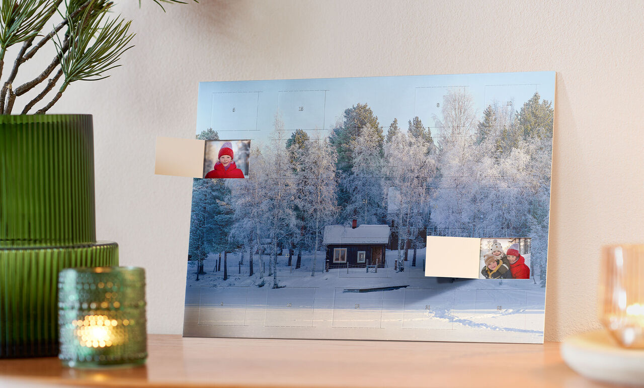 Vinterlandskap med ett trädhus omgiven av snöklädda träd.