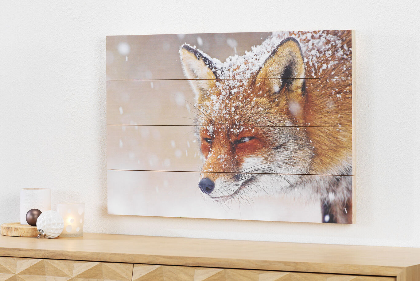 En kreativ väggkonst av en snöig räv som hänger i ett ljust rum.
