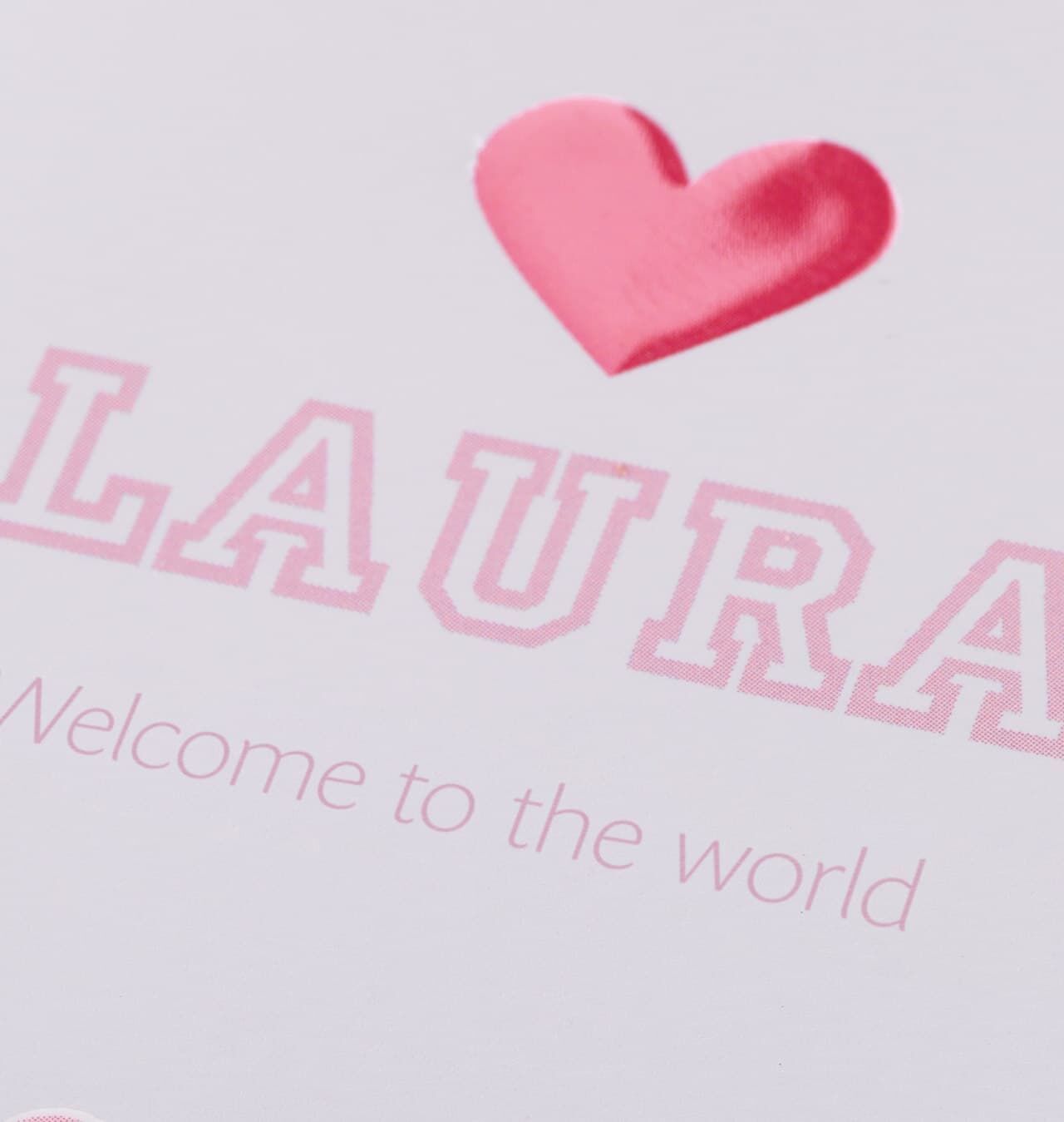 Ett kärleksfullt välkomstskylt för ett barn med namnet LAURA och ett rött hjärta.