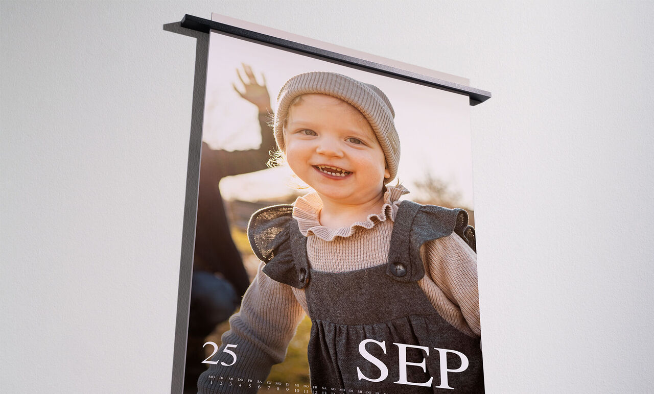 En kärleksfullt designad fotokalender med bild på ett lyckligt barn som ler och visar med händerna