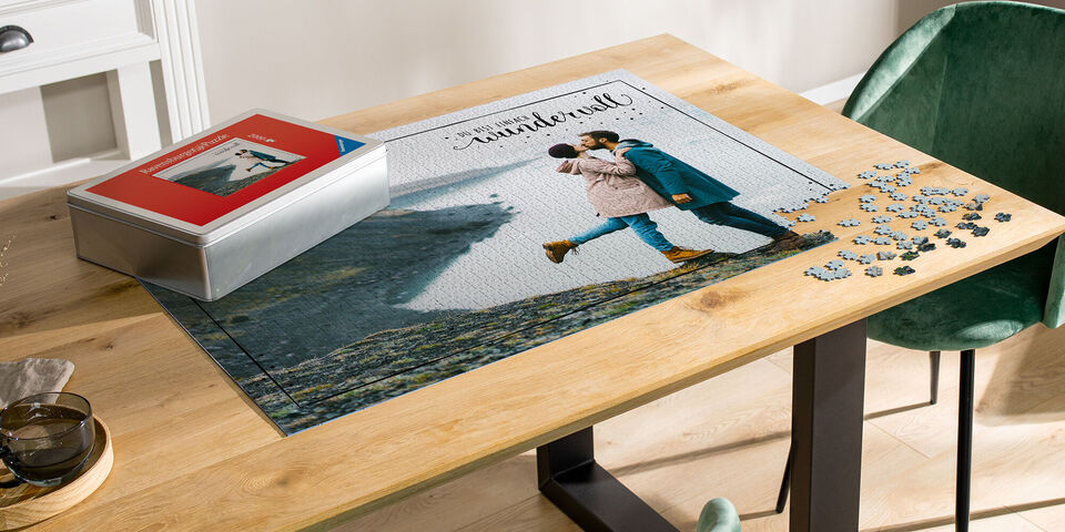 Ett par kysser varandra framför en pussel-skapad landskap.